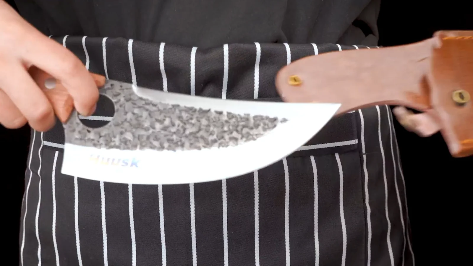 A Huusk blade being drawn out of its leather sheath