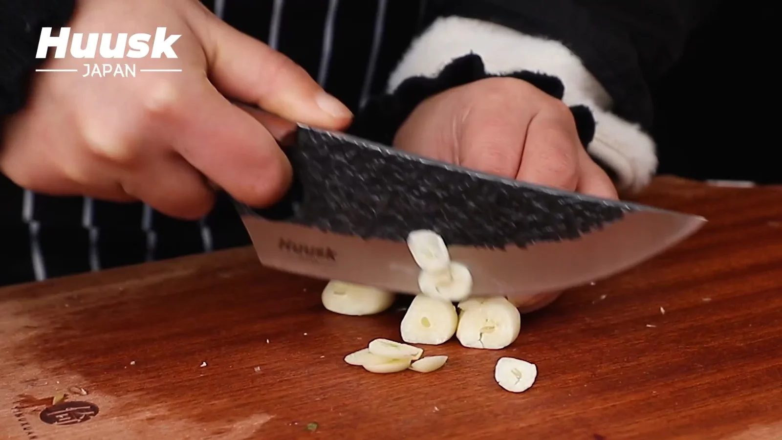 Garlic under the flat of the blade, then chopped with the same edge. The height at the heel is what keeps your knuckles off the board.